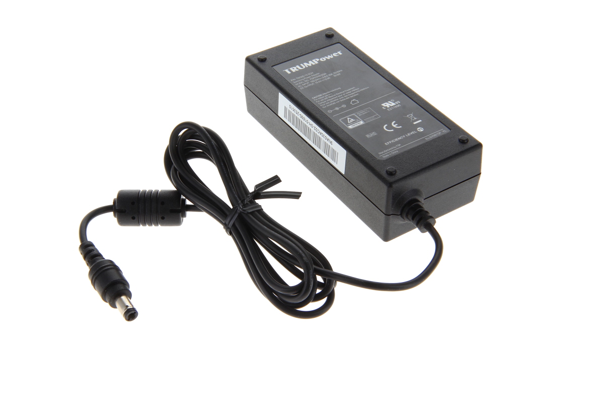 Black, rectangular TRUMPower power supply unit with a coiled cable and a hollow plug. Labels on the casing showing technical specifications and certifications (CE, RoHS). For powering medical devices such as the Schiller Cardiovit FT-1.