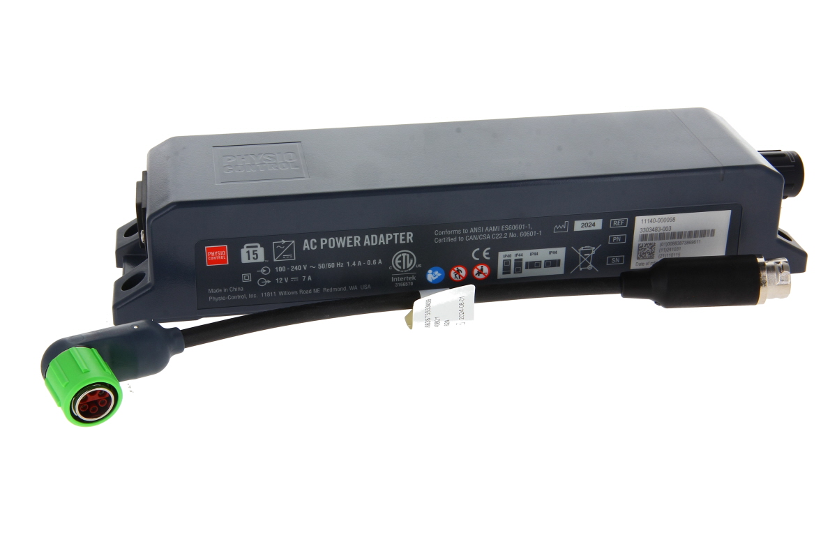 Dark grey ‘ Physio Control ’ power supply (AC power adapter), rectangular, labelled ‘100–240V’ and ‘12V’. Two black cables: one with a green connector, one with a silver plug, for LP15 devices.