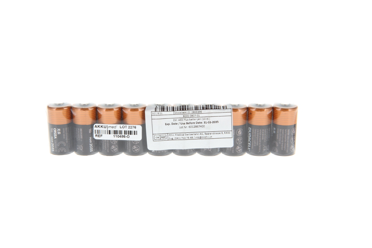 Ten Duracell CR123A batteries in transparent packaging. Cylindrical, dark grey with orange ends. In the centre is a white label with details, including “Zoll AED Plus batteries (10 pcs.)” and an expiry date of 31 March 2035.